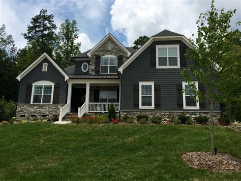 dark green house with gray metal roof|grey house with black awnings.